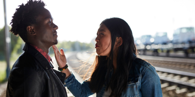 Mulher discutindo com um homem em uma estação de trem