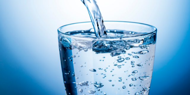 Água sendo colocada dentro de um copo de vidro