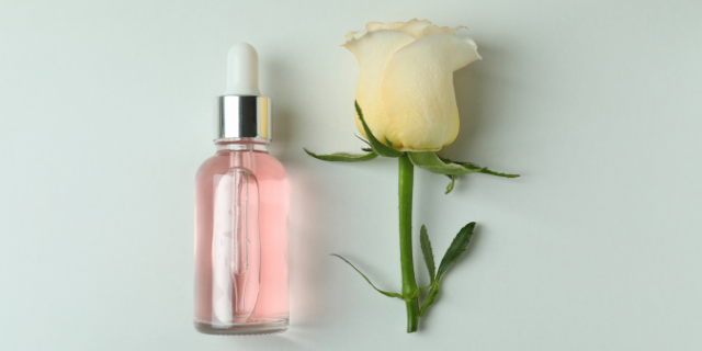 Rosa branca e óleo essencial ao lado