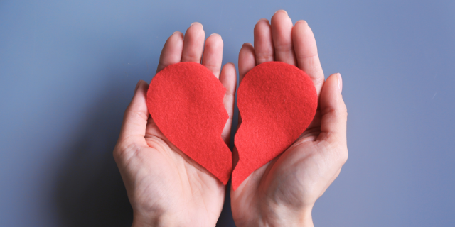 Mão segurando coração partido