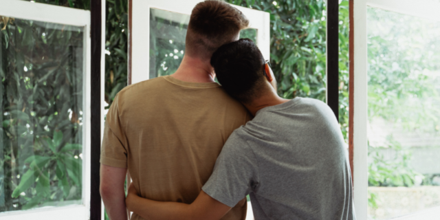 Casal abraçados, de costas para a imagem