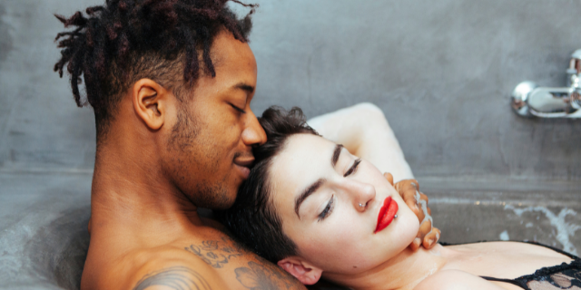 Homem e  mulher sorrindo dentro de uma banheira