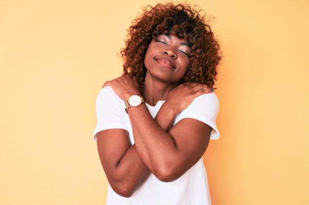 Mulher sorrindo e se abraçando
