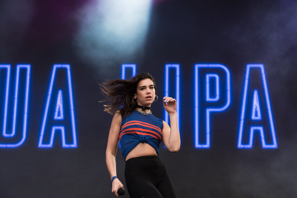 Imagem da cantora Dua Lipa cantando durante show