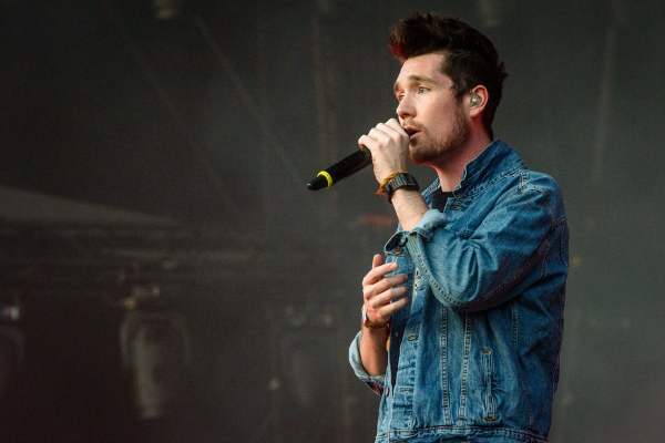 Imagem do cantor Dan Smith, da banda Bastille, cantando durante show
