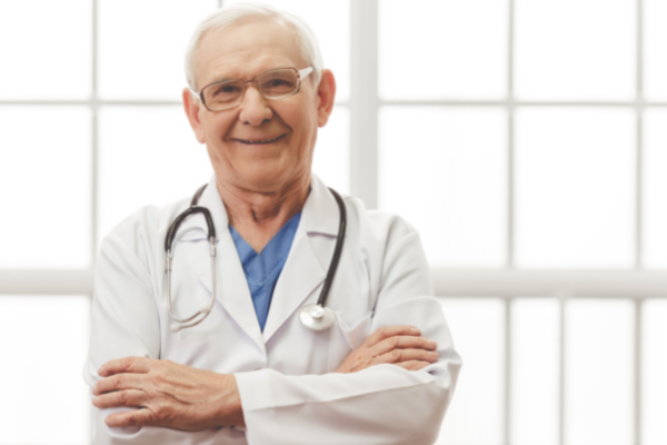 Vadimguzhva / Getty Images / Canva Médico velho com os braços cruzados