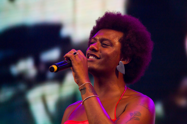 Imagem da cantora Liniker cantando em um show