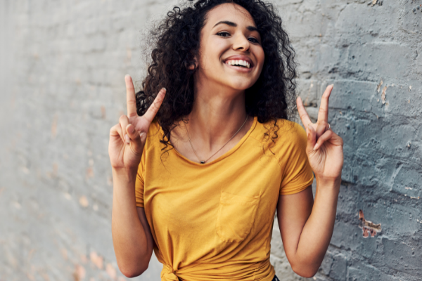 Menina feliz fazendo o sinal da paz com a mão
