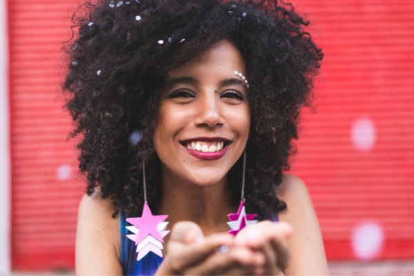 Mulher usando brincos de estrela e sorrindo