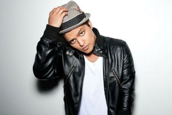 Bruno Mars segurando chapéu e posando para foto