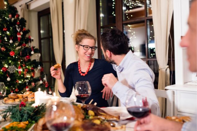 Homem e mulher sorrindo e comendo a ceia de natal