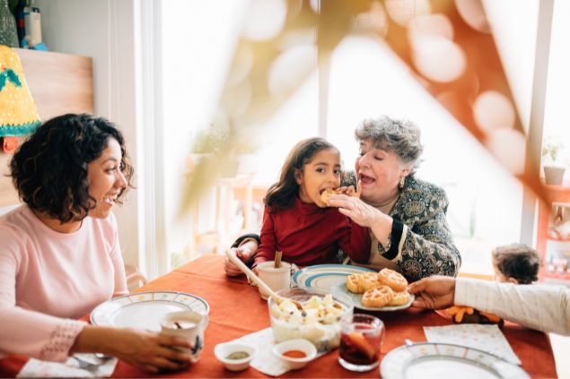 Família sorrindo e comendo pratos típicos do natal