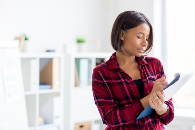 Mulher anotando em uma caderneta