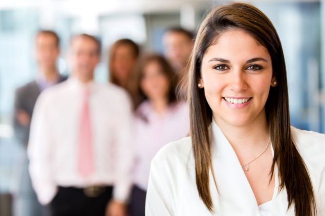 Imagem de uma mulher sorrindo a frente de um grupo