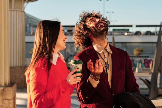 Imagem de um casal um do lado do outro dando risada