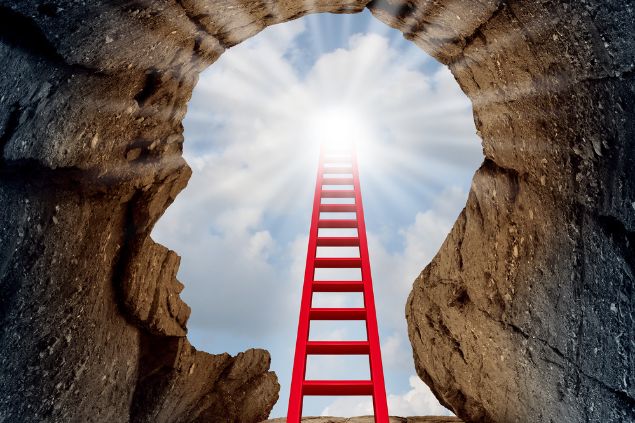 Imagem de uma rocha aberta em formato de cabeça, e uma escada a atravessando, até o céu, como se não houvesse fim