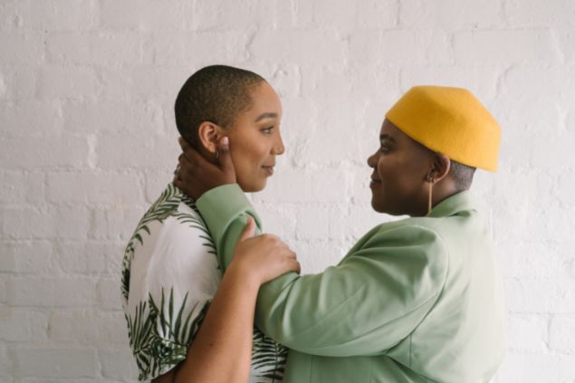 Imagem de um casal de lésbicas se olhando e sorrindo