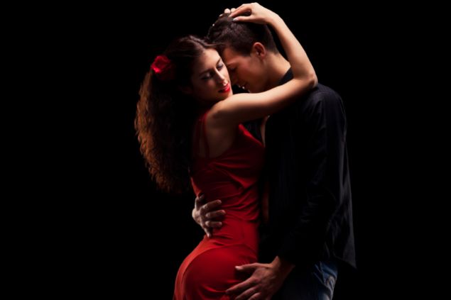 Imagem de uma casal abraçado de forma sensual em um fundo preto