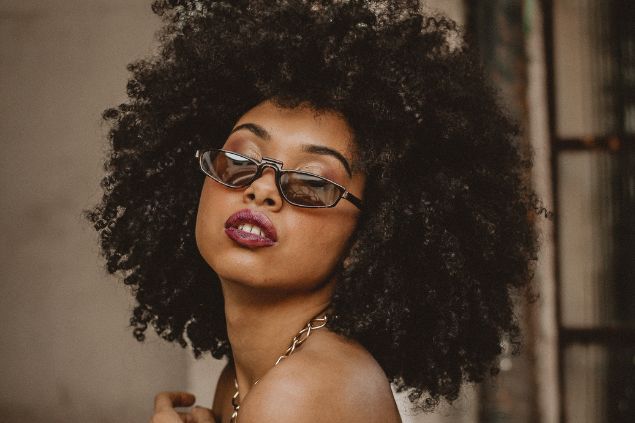 Imagem de uma mulher bonita com óculos de sol e cabelo black power