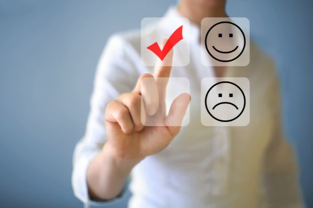 Imagem de um homem como se estivesse em frente d euma tela touch dando check em um rosto de sorriso ao invés do de tristeza