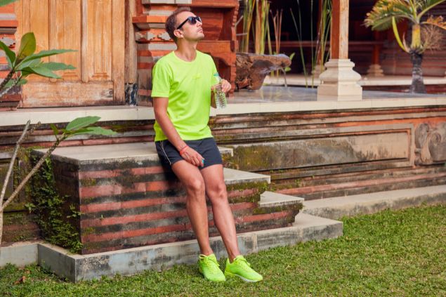 Imagem de um homem olhando pra cima com uma garrafa de água na mão