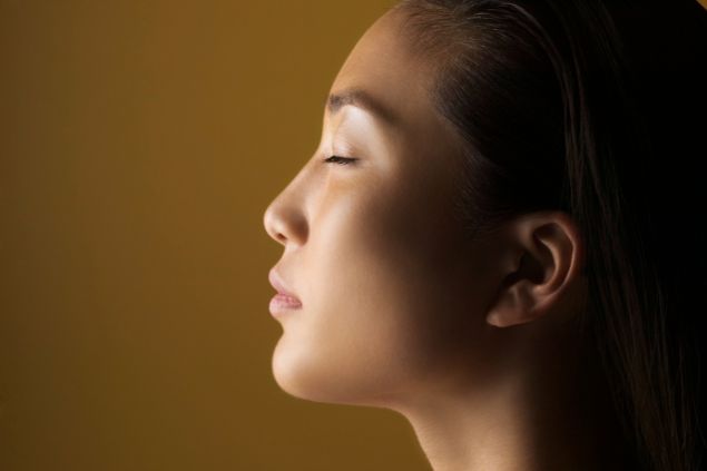 Imagem de uma mulher com os olhos fechados de perfil 