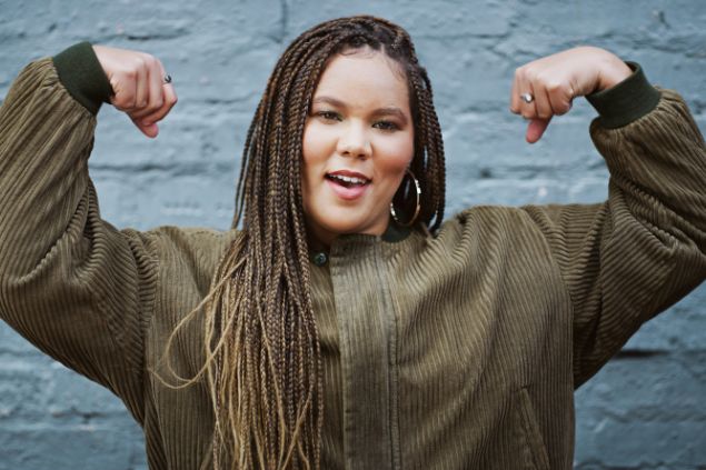 Imagem de uma mulher fazendo o sinal de força com os braços