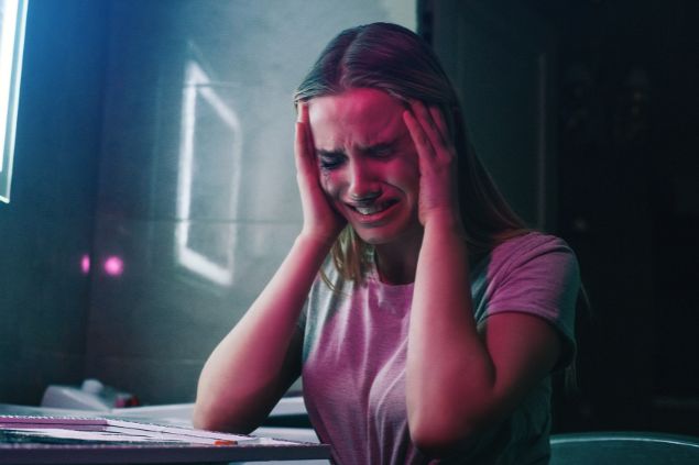 Imagem de uma mulher com expressão de dores de cabeça