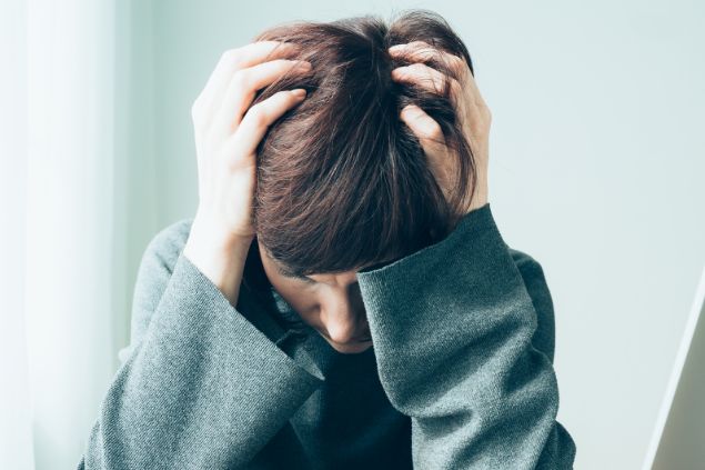 Imagem de uma pessoa com as mãos na cabeça e com semblante de preocupação
