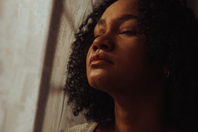 Mulher de olhos fechados pensativa