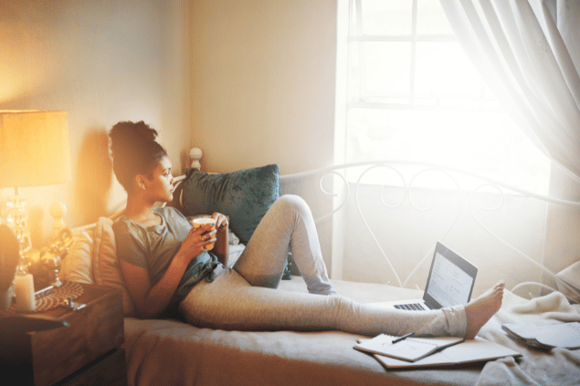 Menina refletindo enquanto toma café e descansa dos estudos. 
