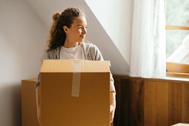 Ketut Subiyanto / Pexels Mulher segurando caixa de papelão. Conceito de mudança.