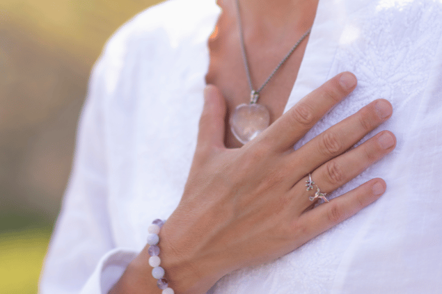 Mão feminina sobre o peito.