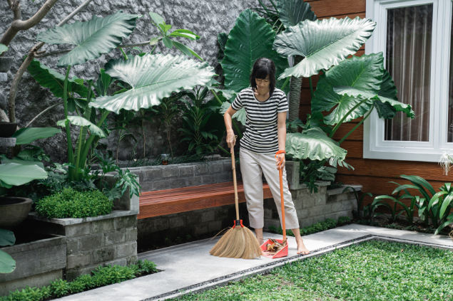 Mulher varrendo quintal