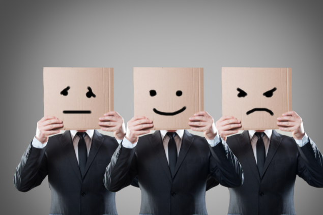 Homens segurando papéis com rostos impressos