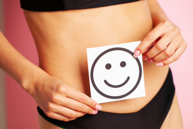 Mulher segurando um papel com rosto feliz perto de sua barriga