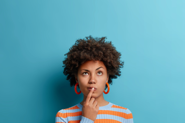 Mulher negra com expressão de pensativa