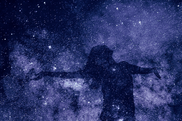 Silhueta de pessoa e ao fundo, o céu estrelado