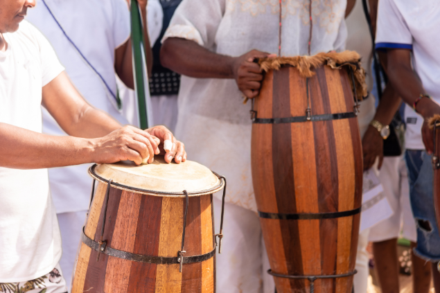 Pessoas tocando instrumento em uma roda de umbanda