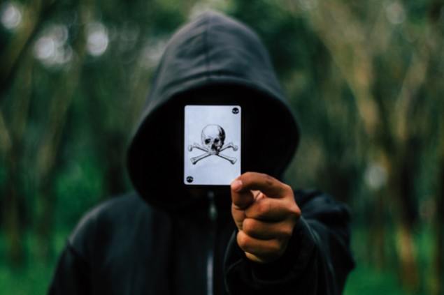 Homem de capuz segurando a carta da morte.