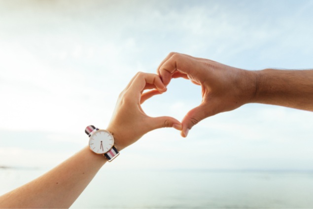 Mãos fazendo um símbolo de coração em meio a natureza
