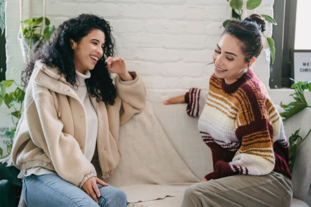 Duas mulheres sentadas no sofá conversando