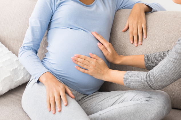 Pessoa acariciando barriga de uma grávida
