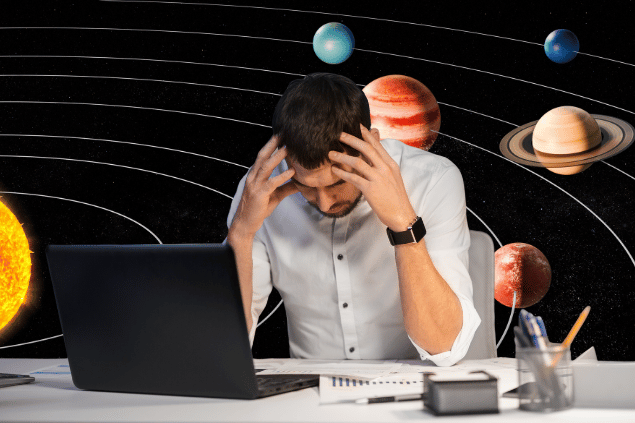 Um homem está trabalhando no seu notebook no período da noite. Ele está com as duas mãos na cabeça, indicando estar pensando ou cansado. Ao fundo, há o sistema solar.