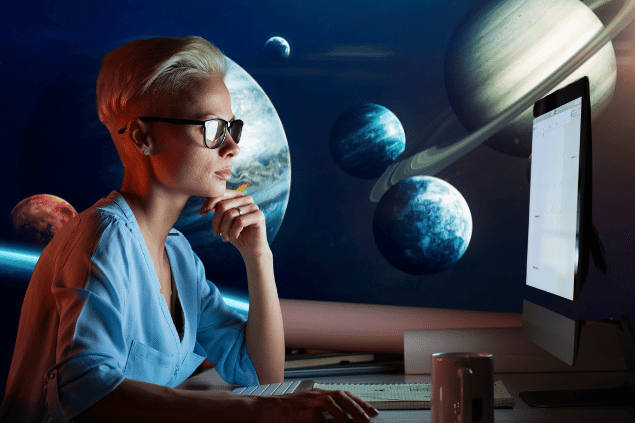 Imagem de uma mulher trabalhando no computador. Ao fundo, há o universo com alguns planetas.