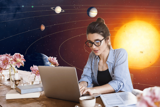 Uma mulher está trabalhando no seu notebook. Em cima da mesa, há flores, livros e uma xícara com café. Ao fundo, há o sistema solar e o universo.