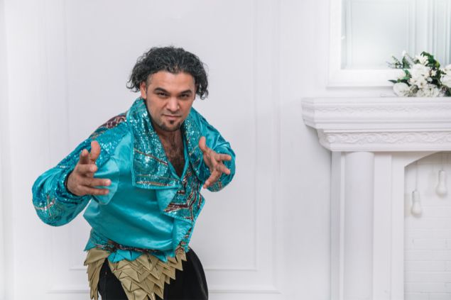 Imagem de um homem cigano, usando uma camisa de cetim azul claro, com enfeites dourados e prateados, simbolizando o cigano Igor da Umbanda.