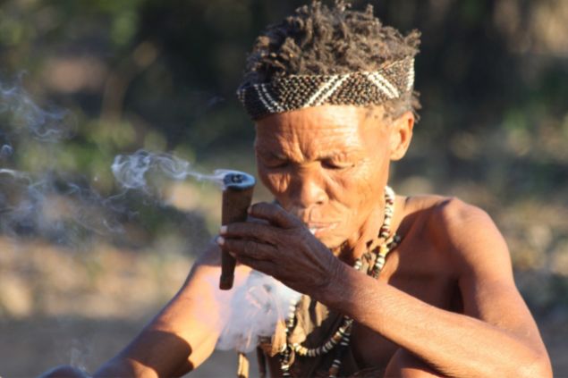 Imagem de um homem indígena fazendo uma defumação com um charuto. A foto traz o conceito do caboclo Tupinambá da Umbanda.