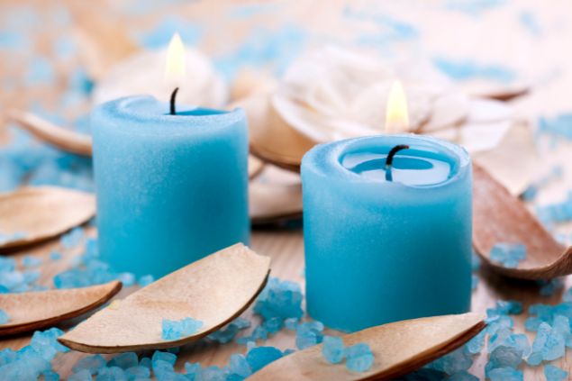 Imagem de duas velas azuis acesas, simbolizando uma das oferendas para a entidade Maria do Cais na Umbanda.