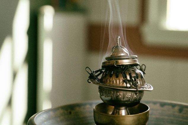 Imagem de um defumador sendo utilizado para limpeza espiritual com ervas, simbolizando um dos rituais para o Zé Caveirinha.